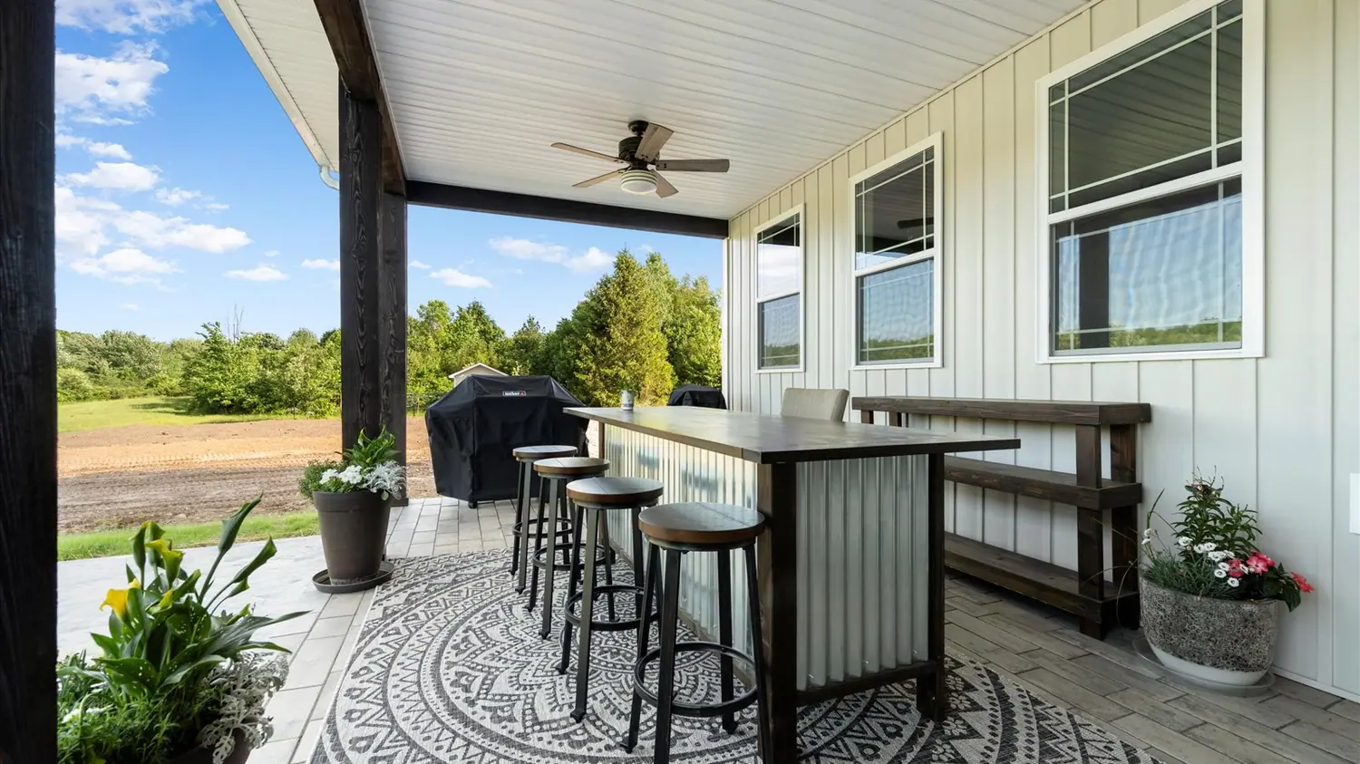 Covered patio with a bar counter and ceiling fan