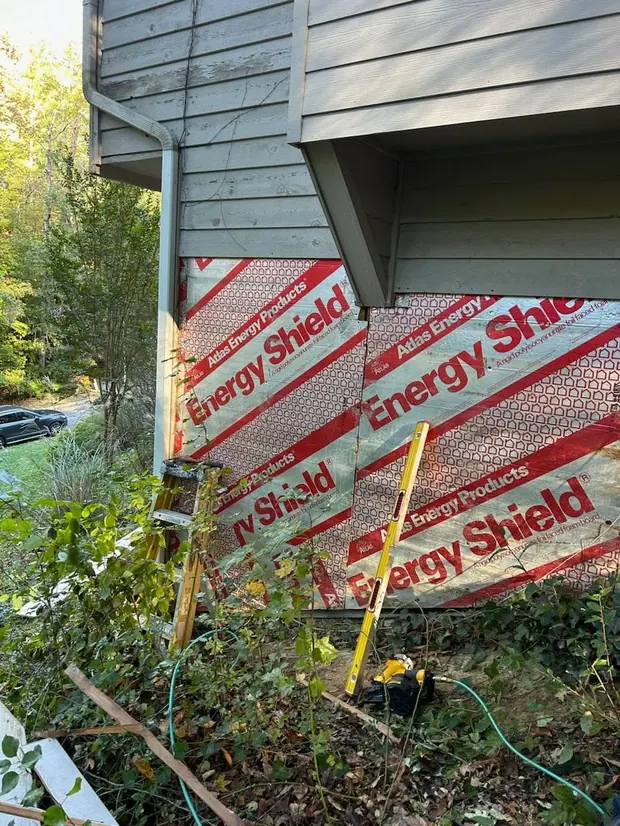 Exterior wall during repair with siding removed and insulation exposed.