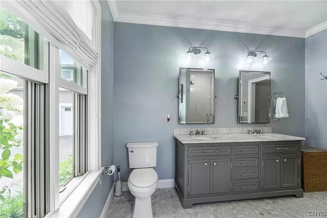 Gray double vanity and marble floor in the primary bathroom in Marcellus, NY.