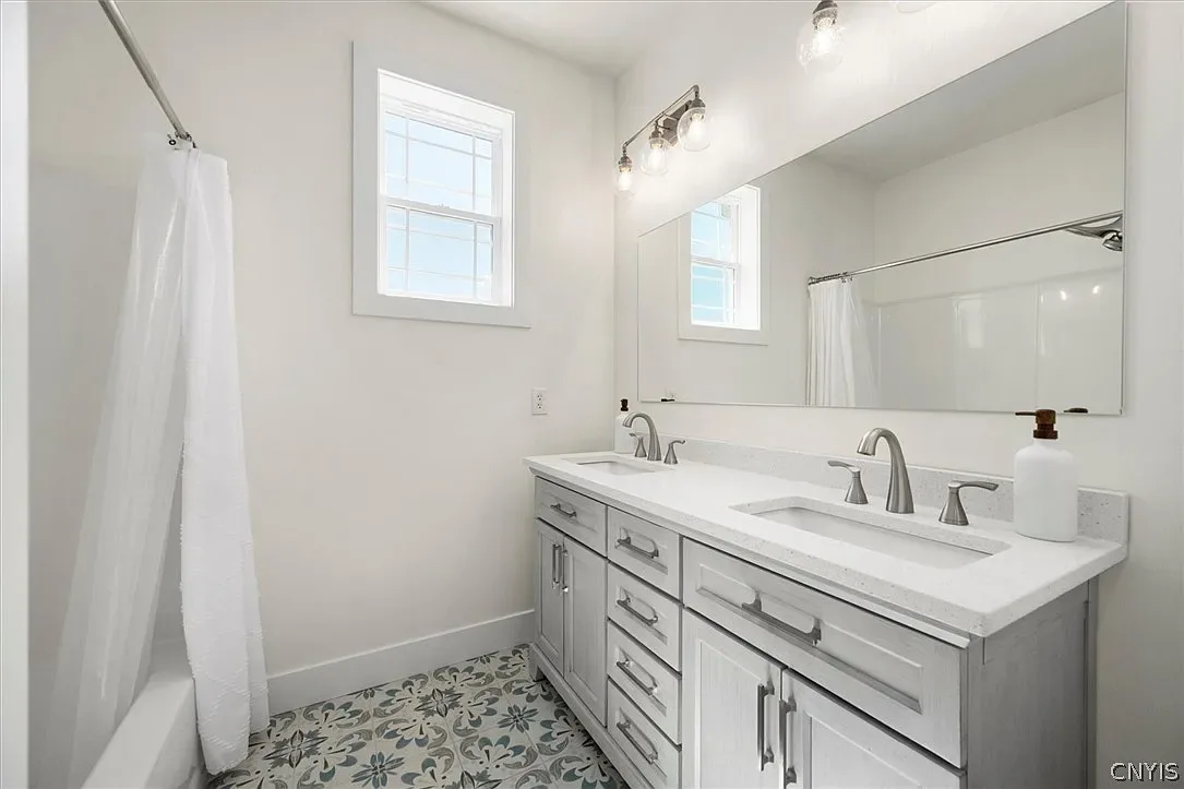 Double vanity with wall mirrors and coordinated lighting in Central Square, NY.