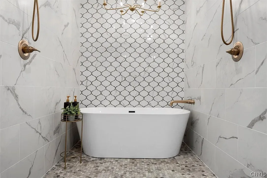 Freestanding bathtub within a tiled shower enclosure in Central Square, NY.