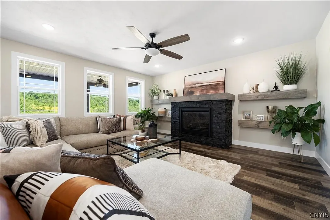 Living room with a fireplace and large windows in Central Square, NY.