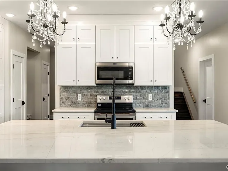 Range wall with white cabinetry and a patterned backsplash in Central Square, NY.