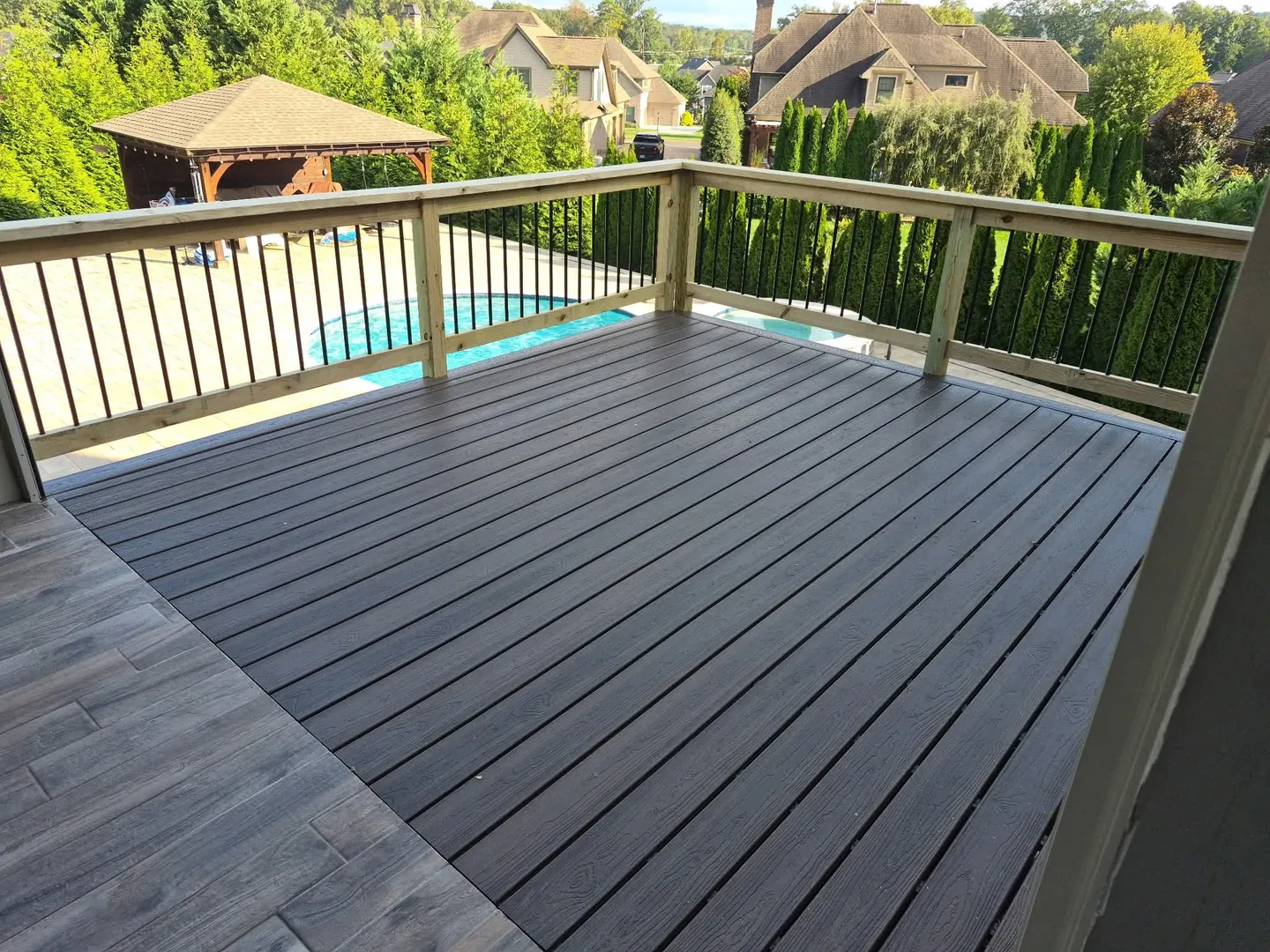 Composite deck with black balusters overlooking a pool in Farragut, TN.
