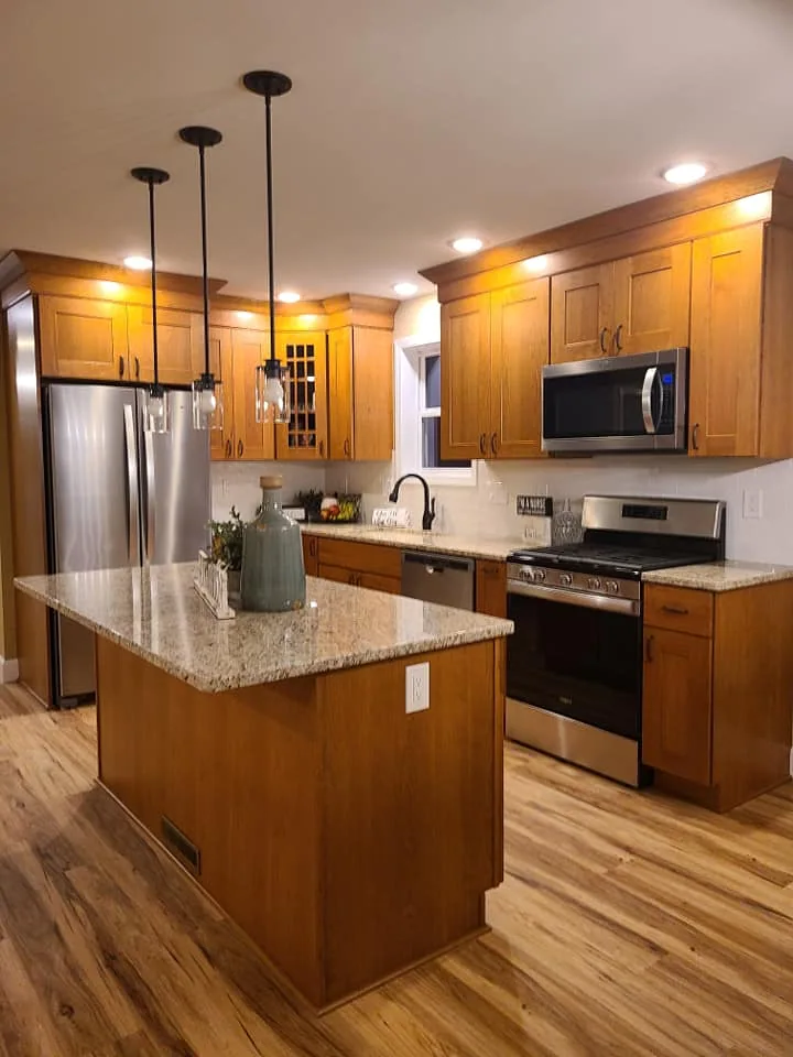 Wood kitchen cabinetry, an island, and pendant lighting in Central New York.