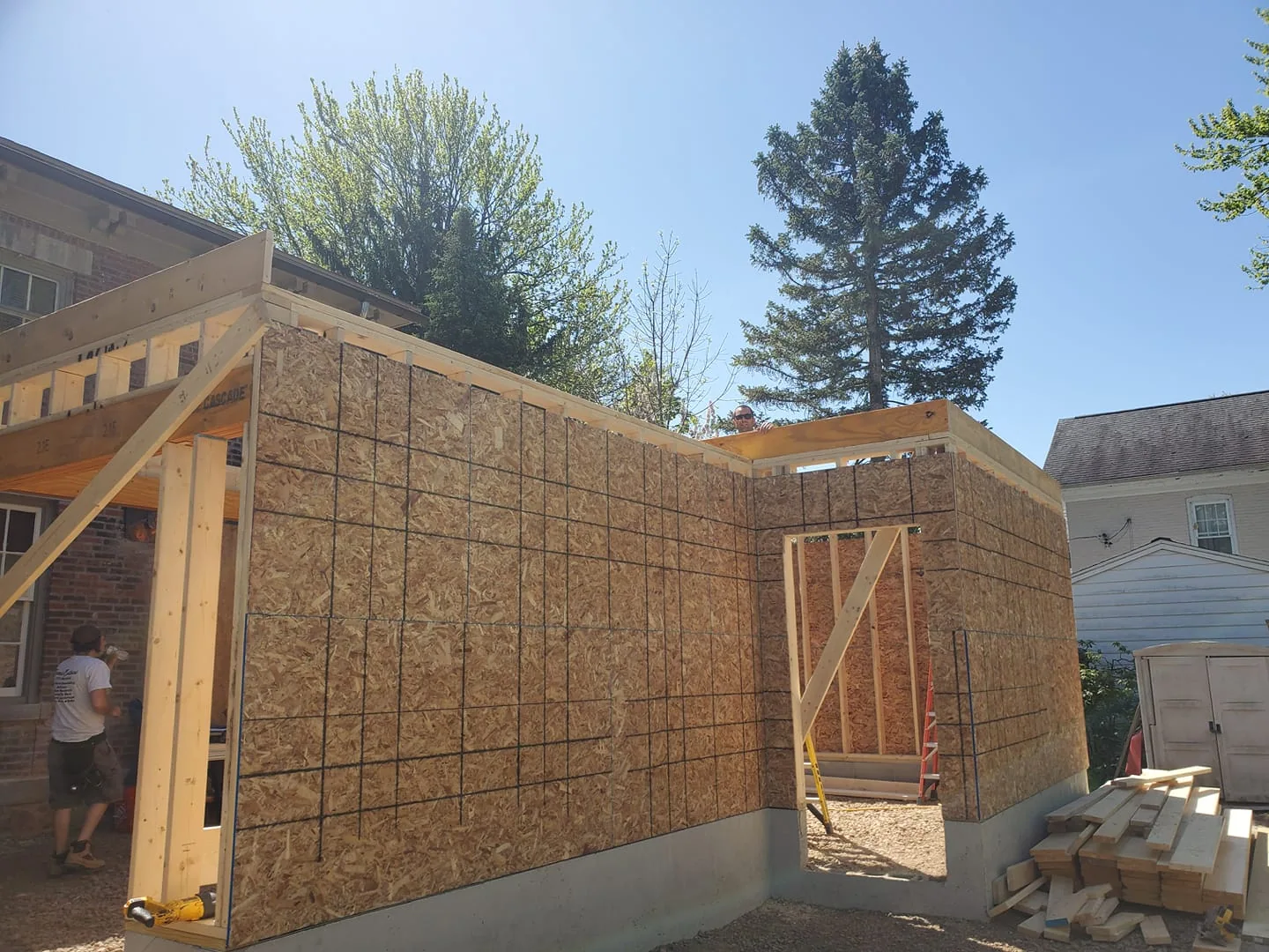 Garage addition wall framing and sheathing beside the existing home in Liverpool, NY.