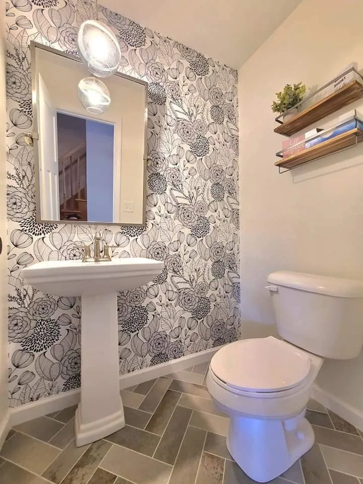 Botanical wallpaper, pedestal sink, and patterned tile in the powder room in Liverpool, NY.