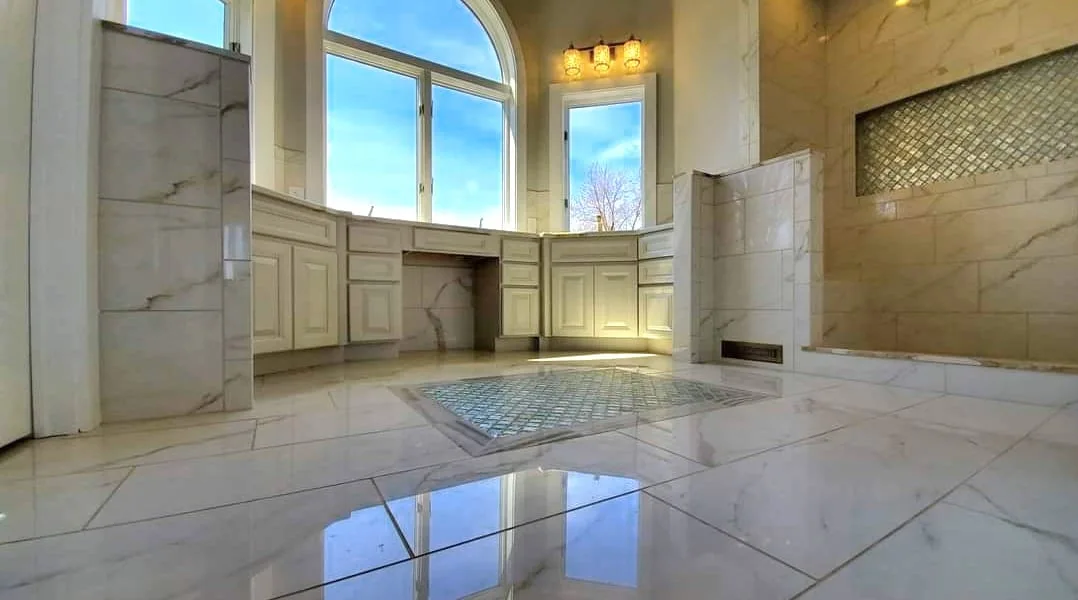 Custom vanity, marble floor, and arched windows in the primary bathroom in Oneida Lake, NY.